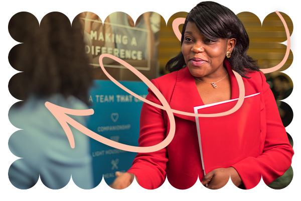 A student shaking someones hand with an orange arrow pointing left